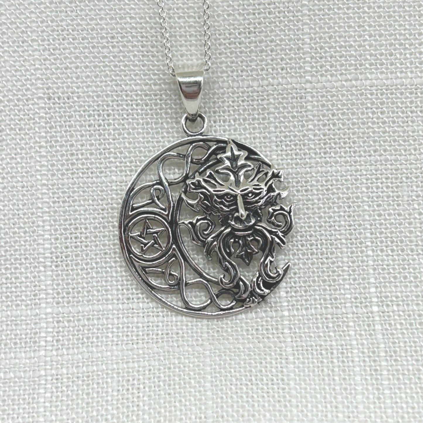 This 925 silver pendant features a Celtic knot style crescent moon with a pentacle within its centre. Filling the space in the moon is a gorgeous Green Man, the mysterious Pagan God who is a protector of all wildlife, woodlands and nature that dates back to medieval times. He is also known by many other names such as Jack o' the Green, Cernunnos, John Barleycorn and Herne of the Hunt. The pendant is approximately 3.6cm long including the bale by 2.6cm wide. Total weight is 7g.