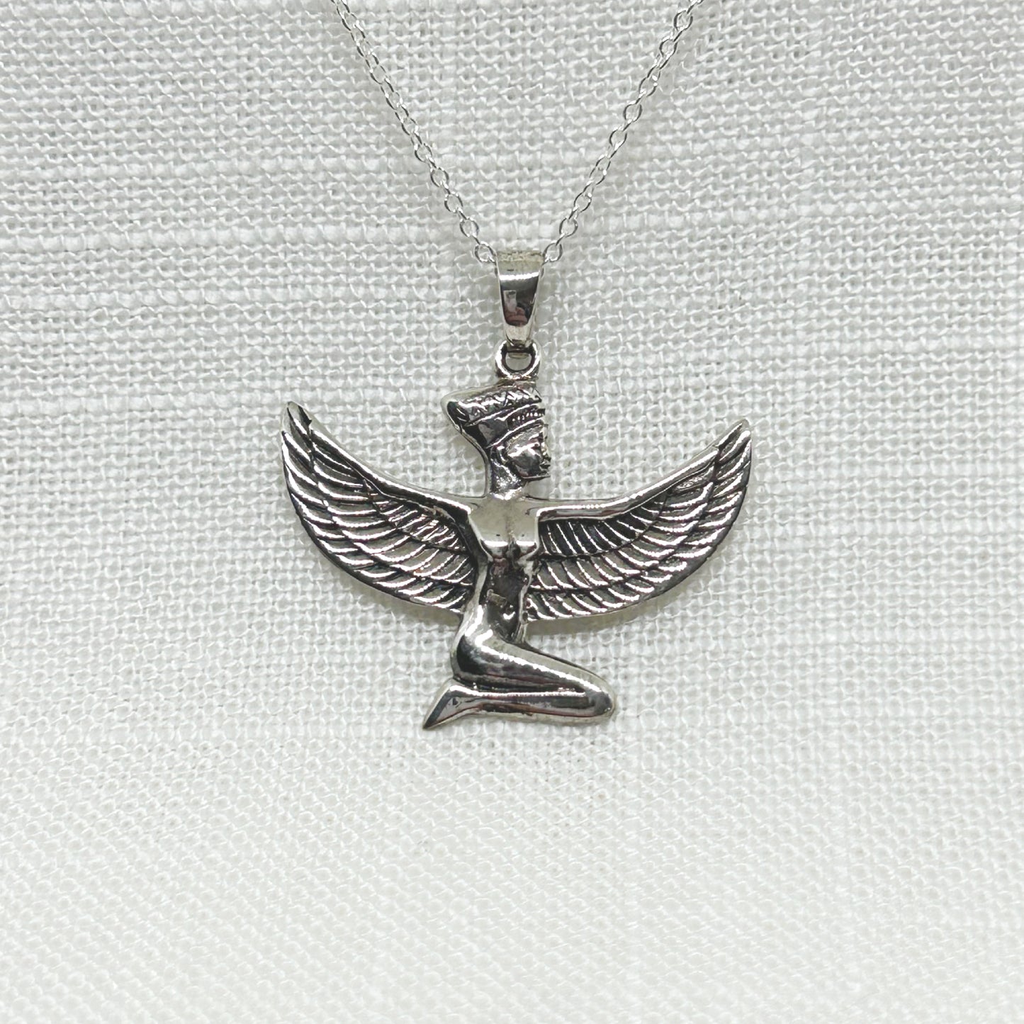 Set in solid 925 silver, this beautiful ancient Egyptian Goddess Isis is kneeling with detailed wings that spread 3cm wide. She is 3cm high including the bale. All pendants come supplied on a 20 inch Sterling Silver Curb Chain and arrive gift boxed. In ancient Egypt, Isis symbolises motherhood, healing, magic, love, death and rebirth.