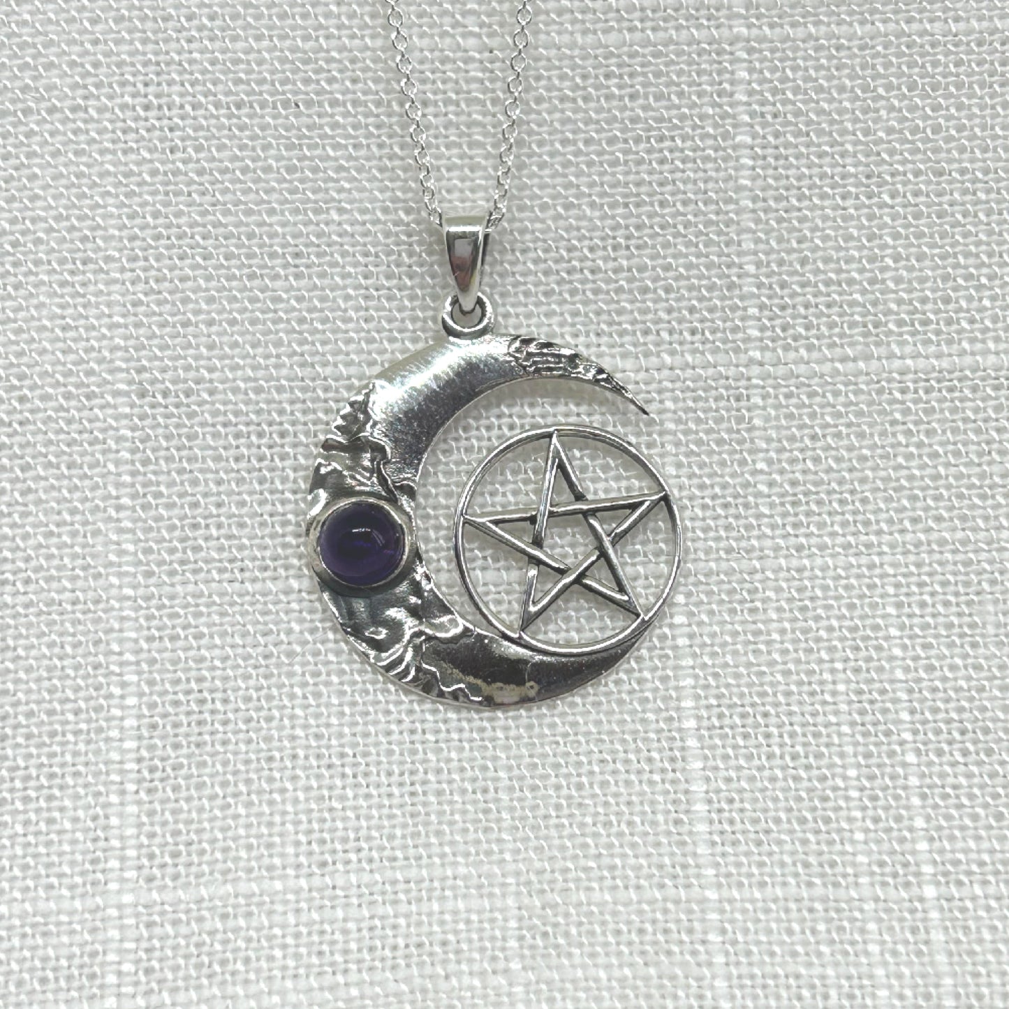 This beautiful, highly polished silver necklace features a crescent moon with an amethyst cabochon and a pentacle symbol. Size approx: W: 2.4cm x H: 3.1cm including bale. Total weight is 4.8g All pendants come supplied on an 20 inch .925 Silver Curb Chain and arrives in a tarnish proof bag inside a gift box.