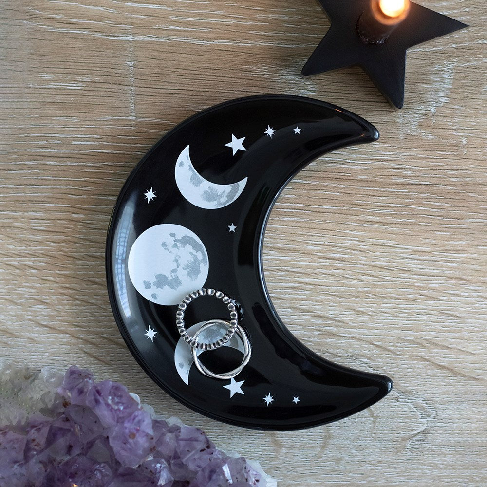 This beautifully decorated ceramic trinket dish is shaped like a crescent moon and features a cool triple moon and stars design. Ideal for holding jewellery and other small accessories. Designed by Something Different and exclusive to the bestselling Black Magic Collection range of gifts. Dimensions: H: 12cm x W: 11cm x D: 12cm