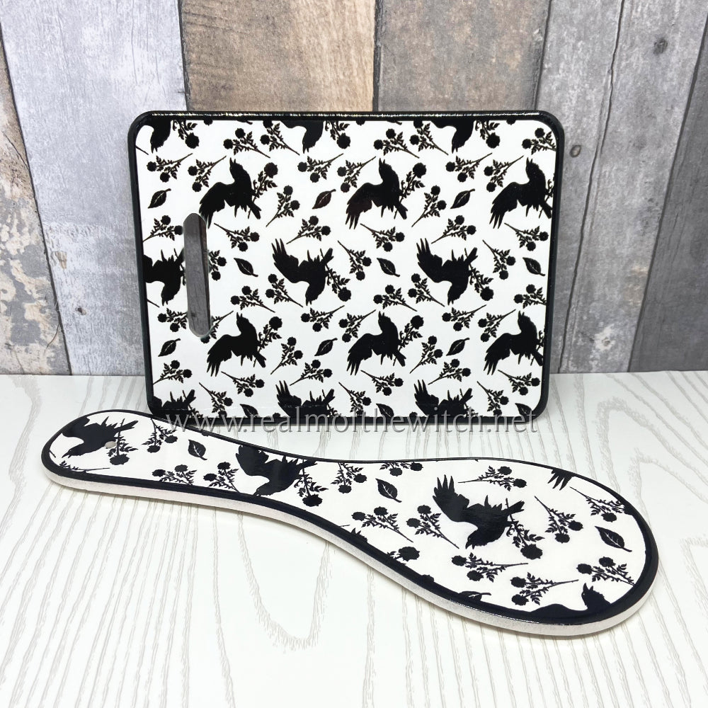 A beautiful trivet and spoon rest decorated in the elegant Alchemy raven and rose design. Both the trivet/cheese/chopping board and the spoon rest are fully functional kitchen essentials and will make a beautiful addition to your kitchen either by the cooker or hanging on the wall.