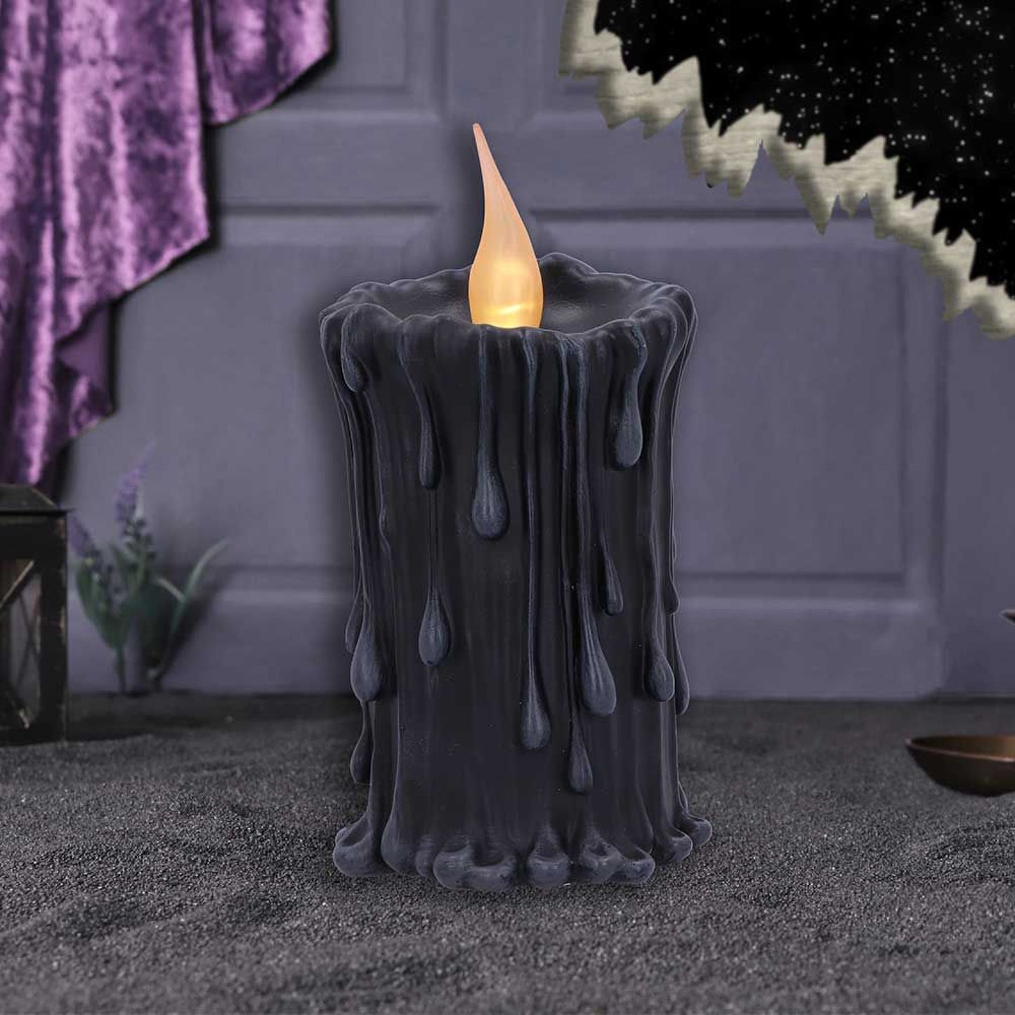 The candle shaped piece, painted in black, imitates a traditional candle, complete with bleeding wax that appears to melt down its sides.  At the top of the candle, there is an LED flame that, when switched on, creates a life like flickering light. Size 18.8cm.