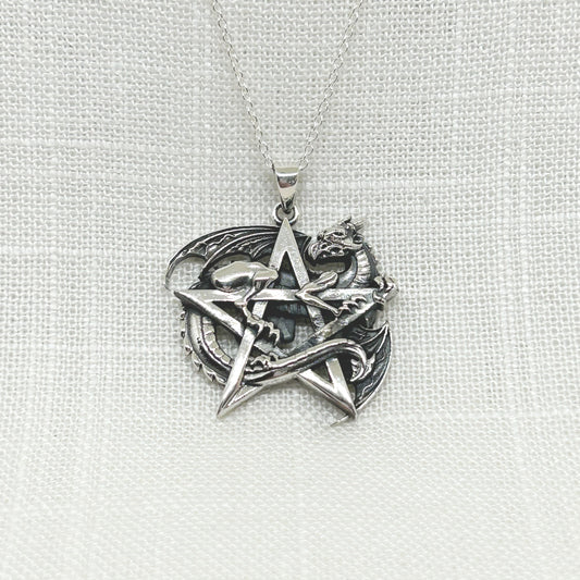 A magnificent dragon guards his sacred pentagram, while his tail entwines between. His wings are stretched out a little to display a stunning pendant in solid sterling silver. This heavy weight necklace is 3.1 cm high including the bale x 3.1 cm wide. Comes complete with a 20" sterling silver curb chain. All jewellery comes gift boxed.