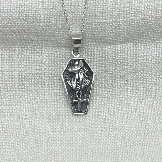 Crafted from .925 silver, this pendant features the Egyptian God of the underworld, Anubis, and his symbol, the ankh. The oxidized background highlights the intricate details of both symbols, making this necklace a unique and eye catching accessory.
The pendant is approximately 3.5cm long including the bale x 1.5cm wide x 1mm thick.
The pendant will come on a 20" sterling silver chain and arrive in a tarnish proof bag inside a gift box.