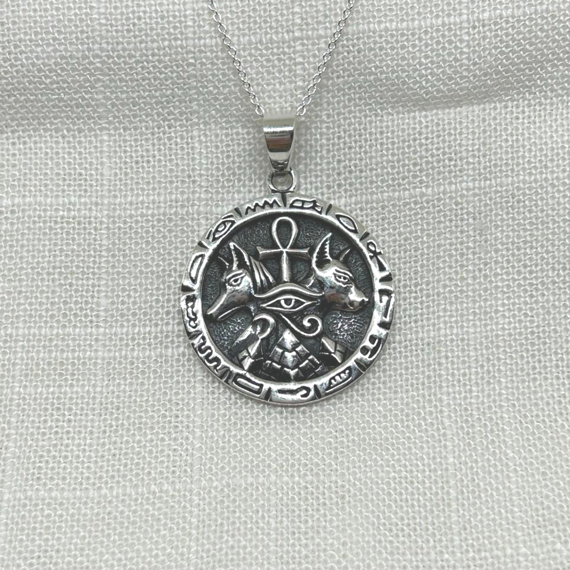 This .925 silver pendant features multiple symbols including an ankh, pyramid, Anubis and eye of Horus.
The oxidized background highlights the intricate details of both symbols, making this necklace a unique and eye-catching accessory.
The pendant is approximately 3.5cm long including the bale x 2.5cm wide x 1mm thick.
The pendant will come on a 20" sterling silver chain and arrive in a tarnish proof bag inside a gift box.