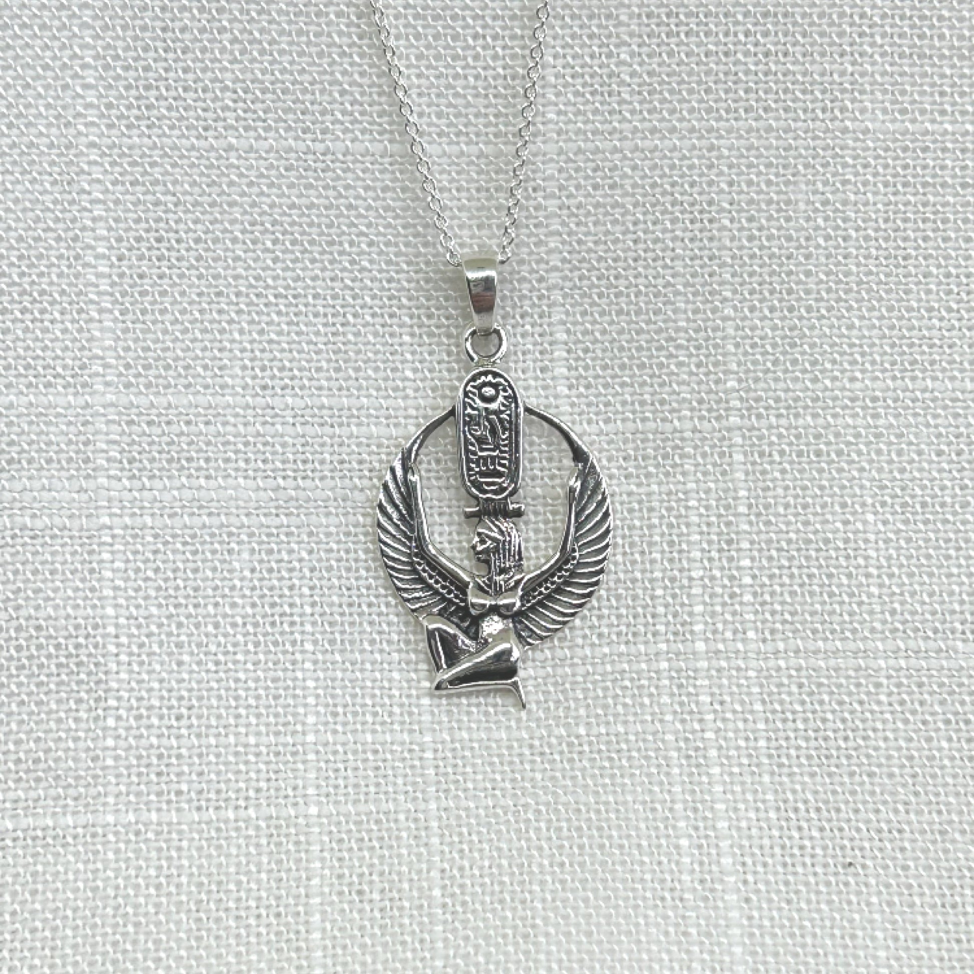 This handmade 925 silver kneeling ancient Egyptian Goddess Isis pendant features hieroglyphics on her throne-like headdress with arms and wings stretched upward. The size of this pendant is 3.5cm or 1.5 inches by 1.9cm or .75 inches wide. Total weight is 4.3g The necklace comes complete with a 20 inch 925 silver chain and is delivered in a tarnish proof bag inside a gift box.