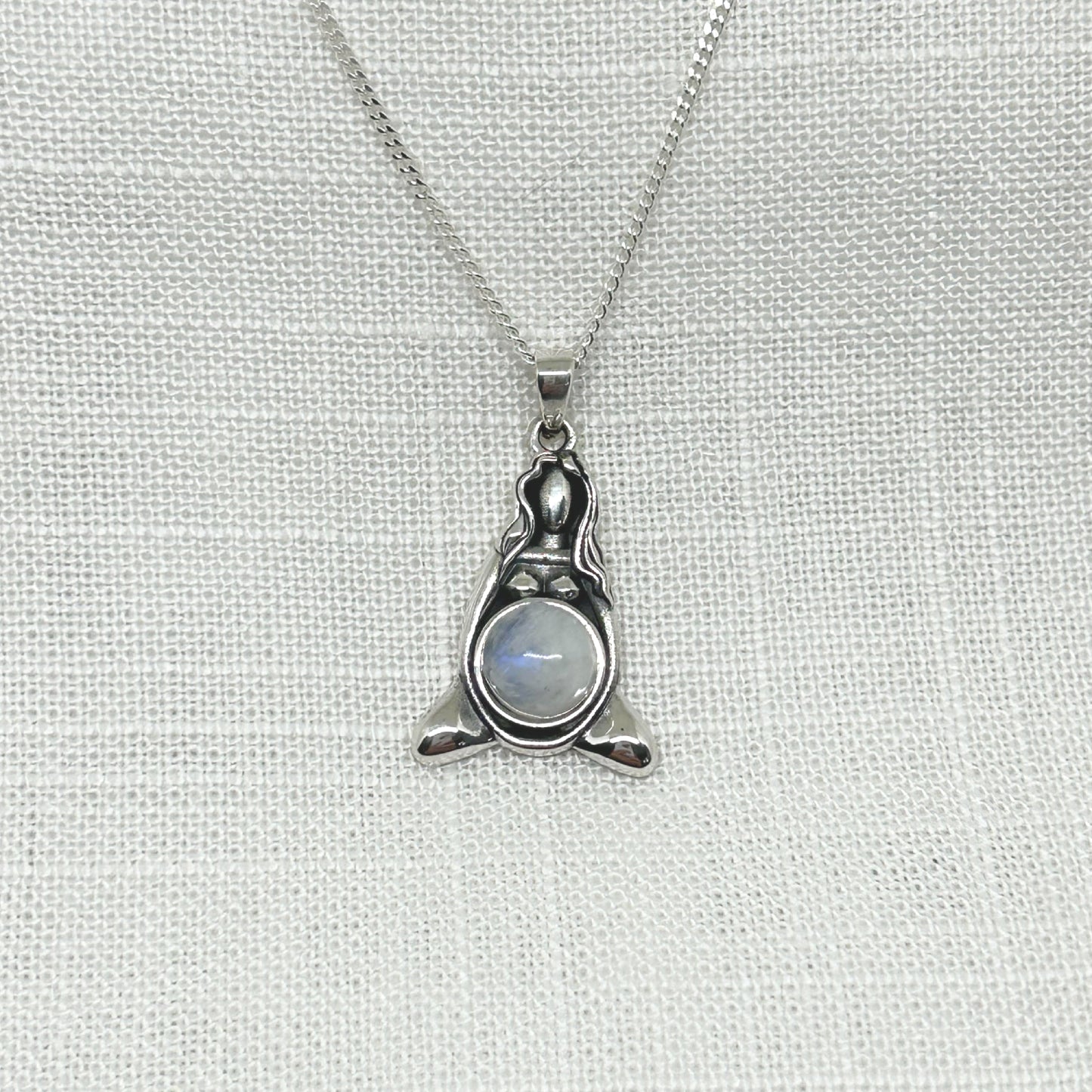 A beautiful depiction of our Mother Earth in .925 silver set with a rainbow moonstone cabochon (1.8cm dia). Size of necklace is 3.1cm high (inc bale) x 1.8cm wide This pendant comes with a 20" sterling silver curb chain. All jewellery comes gift boxed.