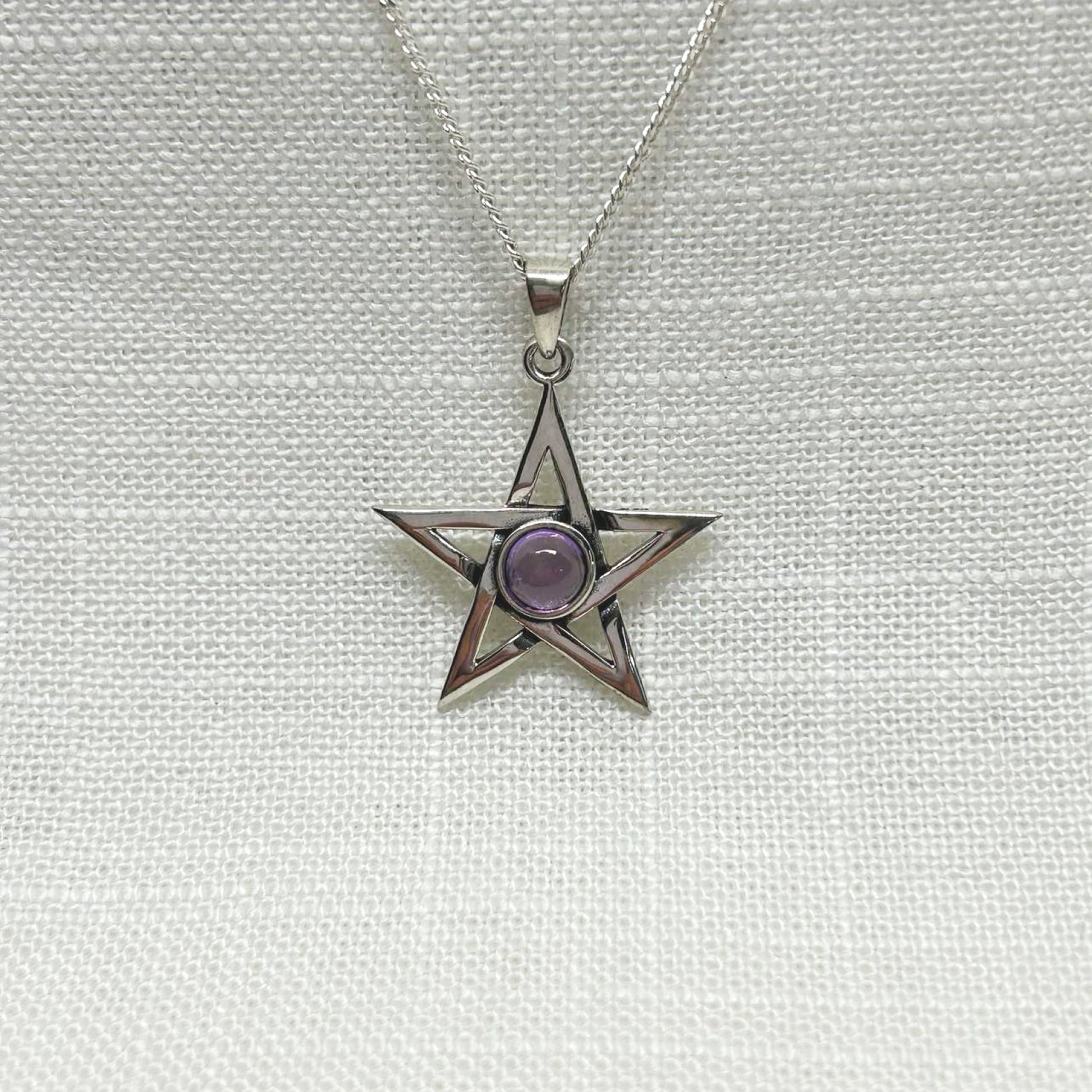 A beautiful .925 silver highly polished pentagram necklace with an amethyst cabochon in the centre. All pendants come supplied on an 20" Sterling Silver Curb Chain and are gift boxed. Size approx: H: 3.2cm including bale, Amethyst cabochon 9mm dia