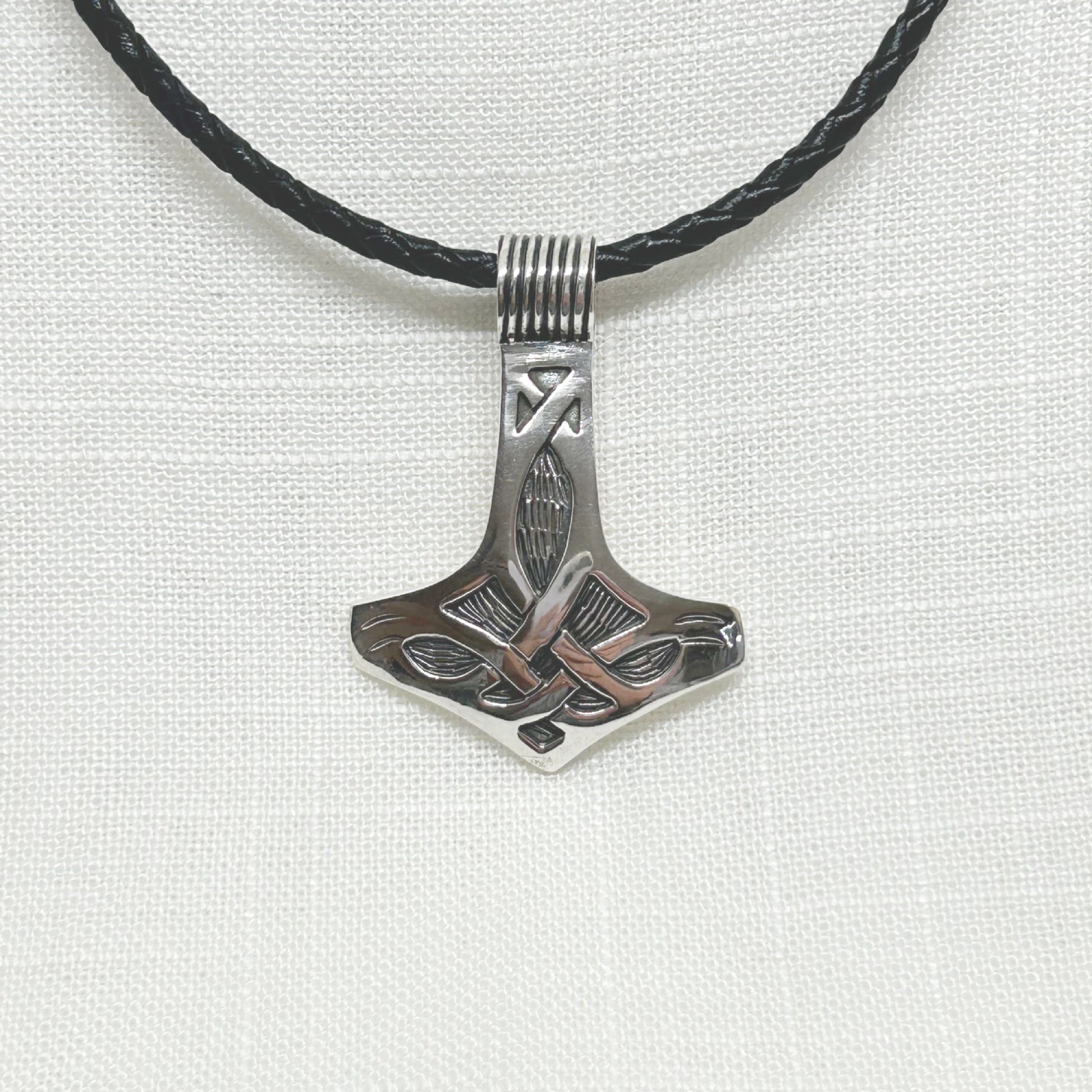 This beautifully crafted large Thor's Mjolnir is set in .925 silver. With exquisite detailing, it is also slightly domed to show off the craftsmanship. The Mjolnir is a Viking amulet of protection and power. The size is 4.7cm in length x 3.5cm wide. This pendant comes on an 18" plaited cylindrical leather cord necklace with sterling silver fittings and weighs 10g/0.35oz. All jewellery comes gift boxed.