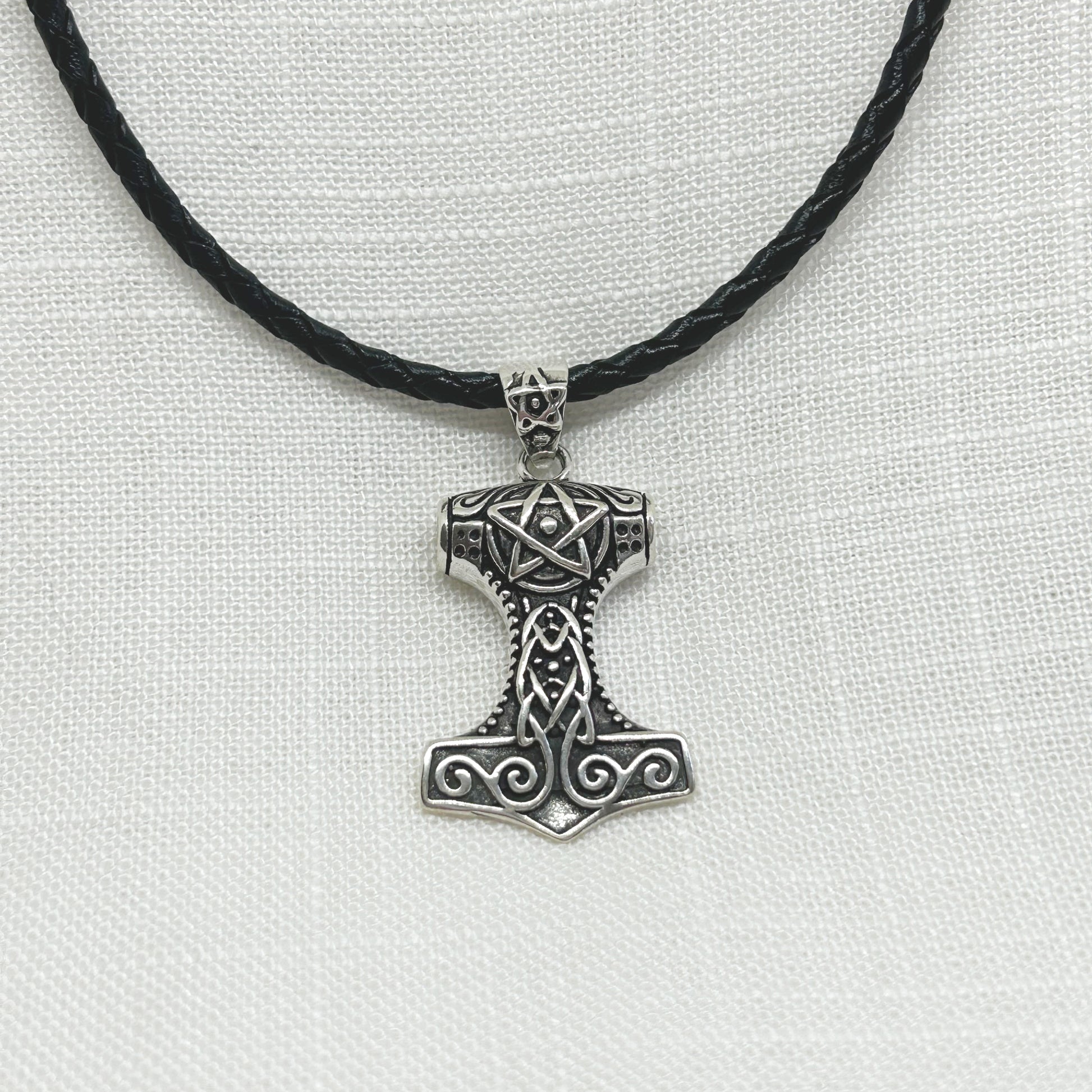 Beautifully detailed and slightly oxidized to enhance the knot work, swirls and pentagram, this Thor's Mjolnir is set in .925 silver. The Mjolnir is a Viking amulet of protection and power. The size is 4.5cm including the pentagram patterned bale x 2.4cm wide. This pendant comes on an 18" plaited cylindrical leather cord necklace with sterling silver fittings. The weight including cord is 10g/0.35oz. All jewellery comes gift boxed.