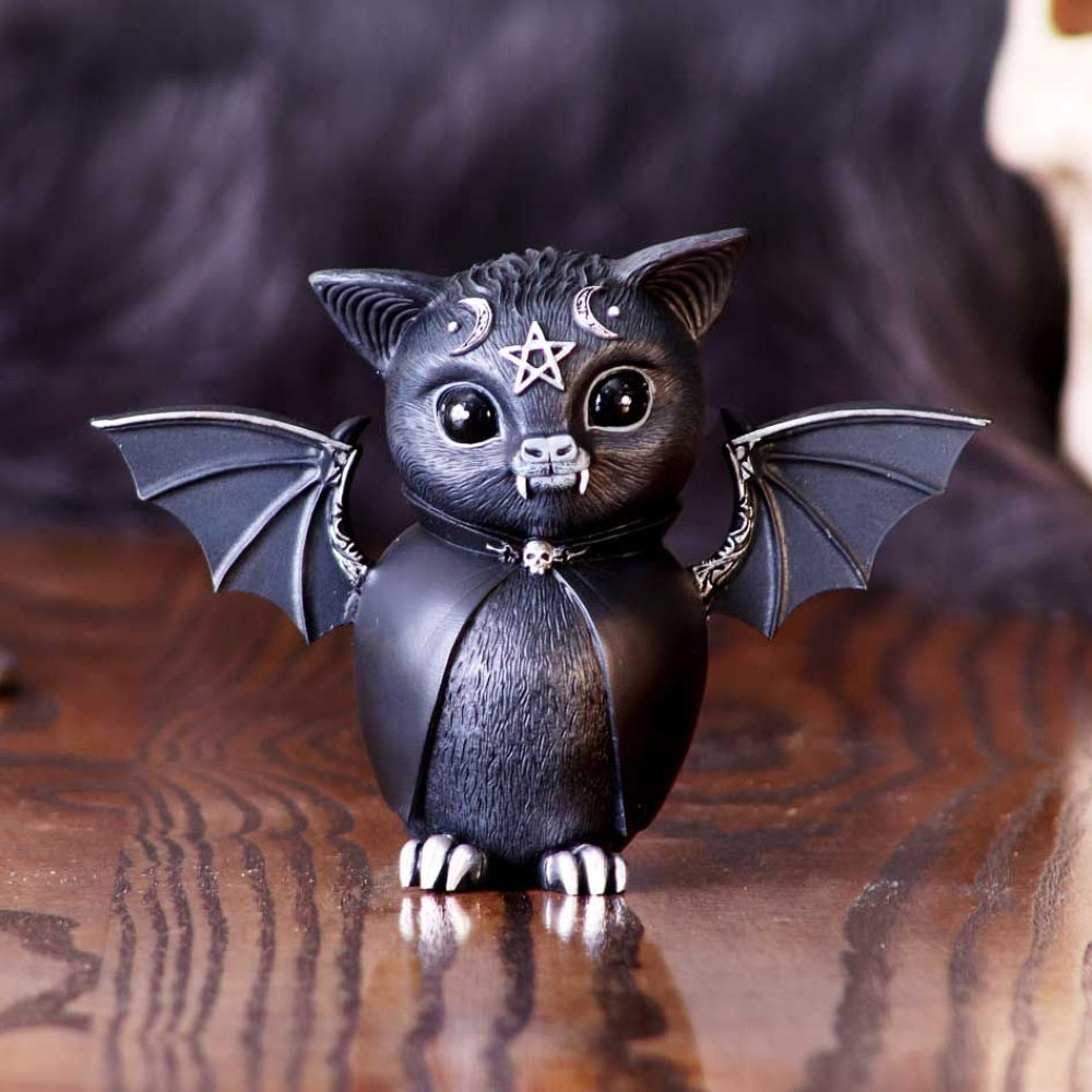 Inside of this bat appears to be a vampire spirit, encapsulated with abnormally large fangs and a black cape. The bat is decorated in ornate silver detailing and symbology. Cast in high-quality resin and carefully hand-painted this figurine is likely to be the cutest occultist you've ever seen.  Size: 13.5cm