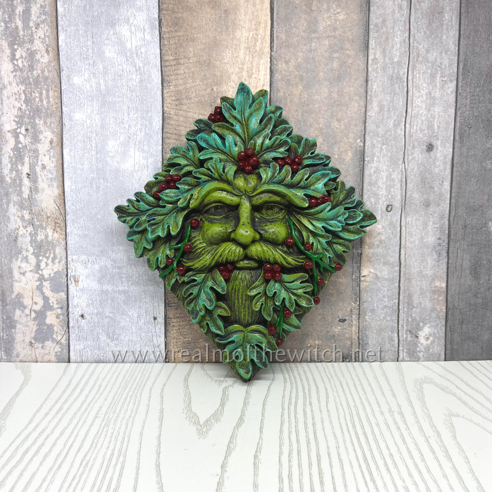 With a cheery face formed from fresh green oak leaves and slightly blue-green around the edges of each leaf, this winter tree spirit will look festive indoors or outside. He is also adorned with bright red berries. This piece will bring nature, magic and mystery into any home. Cast in fine resin and hand-painted.