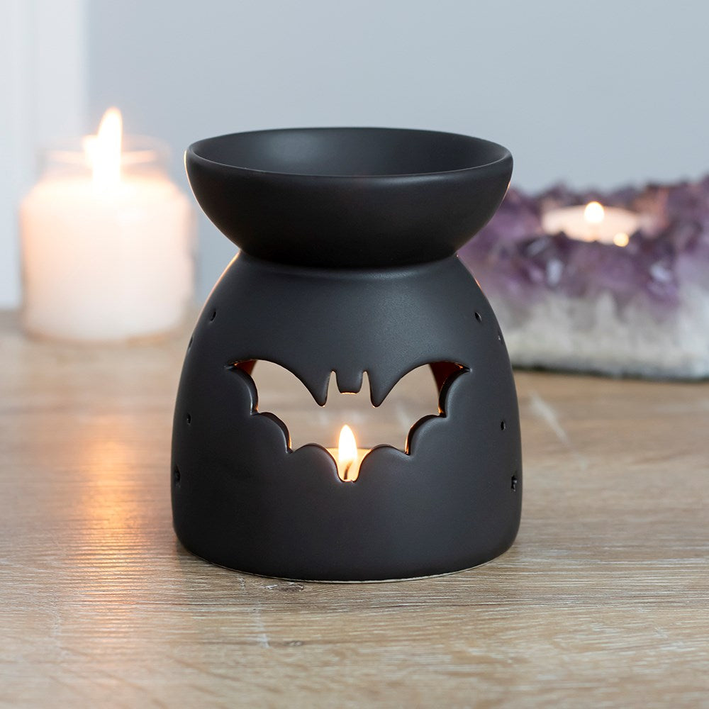 This black ceramic oil burner features a cut out bat design and a cool, matt finish. Compatible with both fragrance oil and wax and perfect for Halloween or spooky decor! These burners are compatible with wax melts and fragrance oils (sold separately).  Dimensions: H: 10cm x W: 9cm x D: 9cm Material: Ceramic