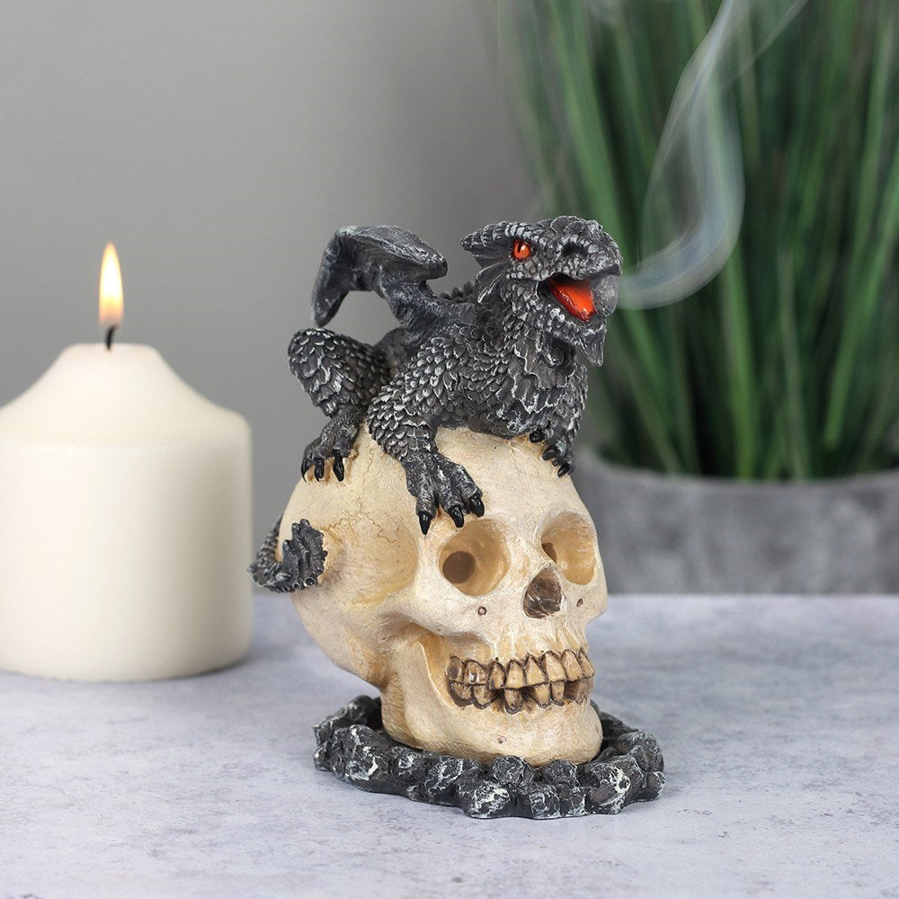 Designed by Anne Stokes this eye-catching incense cone burner features a black dragon sitting on top of a skull. When an incense cone is lit and placed inside the smoke from the cone will flow through the eyes of the skull for an impressive feature piece.   Dimensions: H: 11cm x W: 7cm x D: 10cm Material: Polyresin