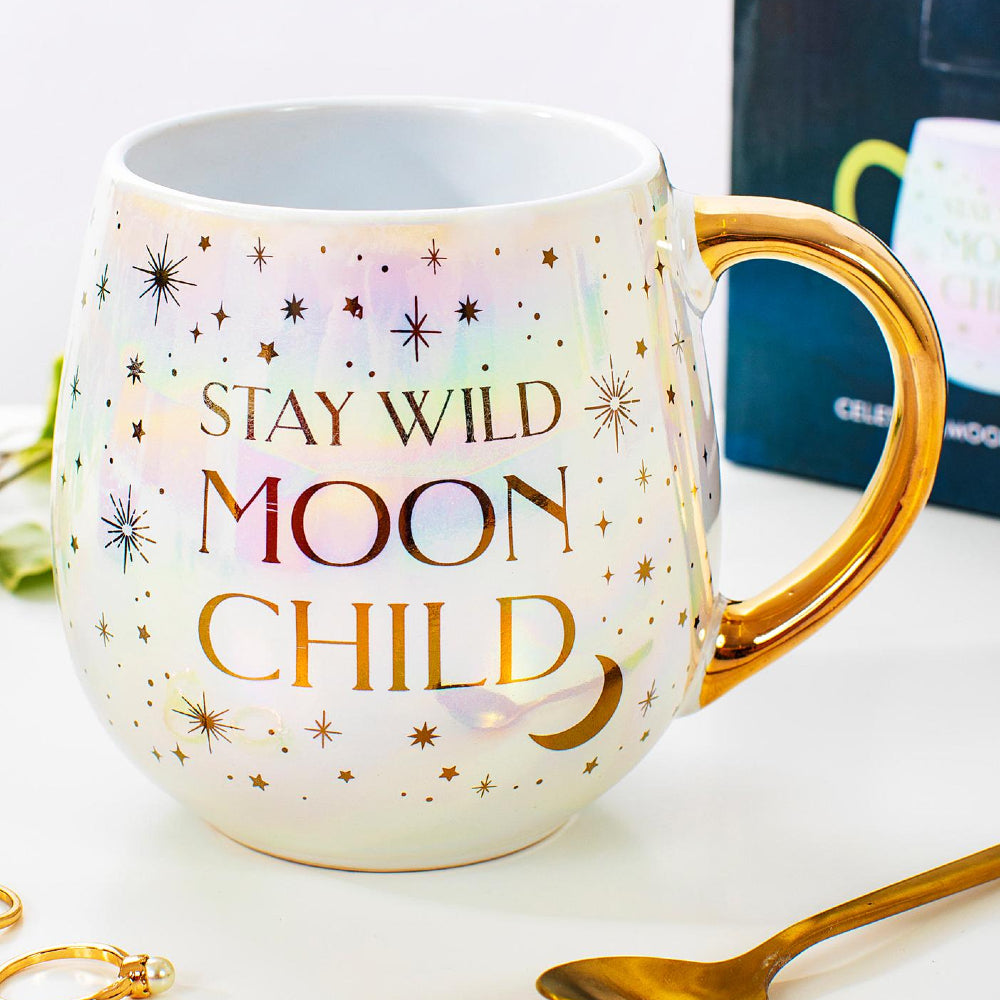 This Celestial Moonchild Mug features iridescent highlights inspired by the hues of the night sky and twinkles of galaxy gold on the body of the mug, as well as the handle. Following a pretty gold and white colourway. Plus, the beautiful quote 'Stay Wild Moon Child' on the front and the back.   Mug comes gift boxed. Size: L8 x W8 x H11 cm Holds 500ml liquid Not suitable for use in dishwashers or microwaves.