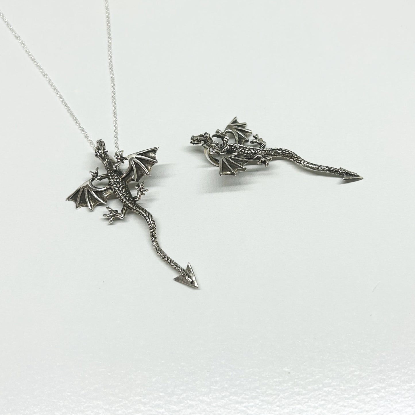 This stunning dragon necklace is set in 925 silver.  The detail on the dragon has been slightly oxidised to show off it's scales, head and wings.  Featuring a hidden bale under the body, when worn it is slightly raised from the neckline.  With wings outstretched, it measures 3cm wide.  From the head to the tip of the tail is 5cm long.  All pendants come supplied on a 20 inch silver chain and arrive in a tarnish proof bag inside a gift box.