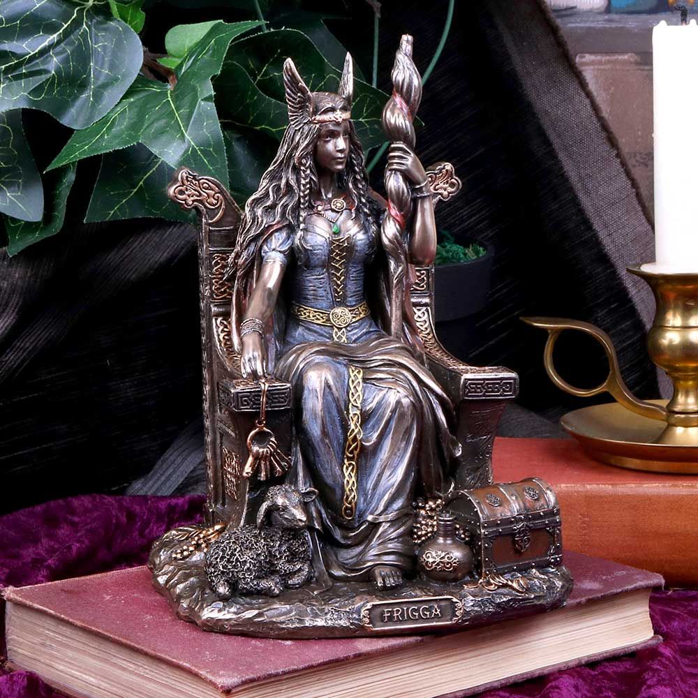 Cast in the finest resin before being given a bronzed finish. Frigga is the wife of Odin, leader of the Gods and Mother to Baldur. Here she is seen sitting on an ornately patterned throne, holding a large staff in her left hand and a set of keys in her right. A small lamb lies by her feet, along with a detailed chest and vase. This Goddess of marriage and protector of home and families would make a welcome addition to any mythological collection. 