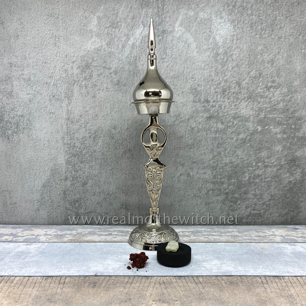 A gorgeous silver plated metal goddess with intricate spiral patterns. This versatile piece can be used for incense cones, a charcoal burner for resin and loose incense or as a candelabra without the dome. The holder (the goddess part) is 15.5cm or 6 inches high. The whole assembly, when the dome top is added, is 23cm or 9 inches high.