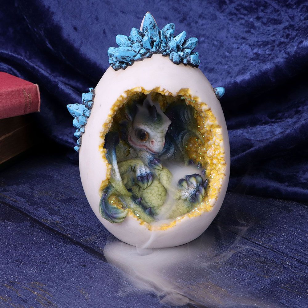 Featuring bright-green scales with dark-blue accents on their claws, horns and wings, this enchantingly adorable dragon is looking into the world for the first time from its glistening citrine-coloured home which doubles as the most magical backflow incense burner. Cast in the finest resin before being expertly hand painted, this is the ideal gift for any lover of mythical beasts! Only Backflow incense cones can be used with this product. Features an LED light which takes 2 x AA batteries (not included).