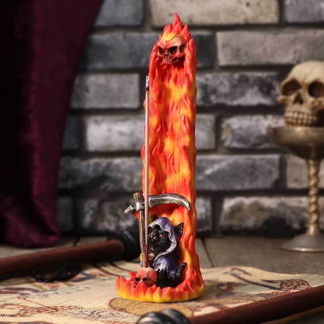 Hell Puss sits on a flaming perch. This cute kitty is cloaked and holds a small scythe in his paws. Behind this devilish feline is a wall of fire topped by a flaming skull. The perfect resting place for your favourite incense sticks, this piece is great for those who wish to raise a little hell!