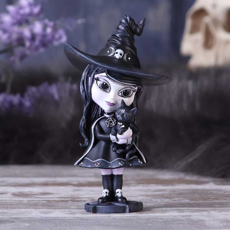 Hexara the adorable cult cutie Witch, can be seen wearing a black cape and Witches hat, whilst cuddling her feline companion.  Decorated in ornate silver detailing and occult symbology, stood upon a pentagram stand.  This figurine has been cast in the finest resin before being carefully hand painted and is likely to be the cutest occultist you've ever seen.  Making it the perfect addition to any Witch or Gothic collection. Size 15cm
