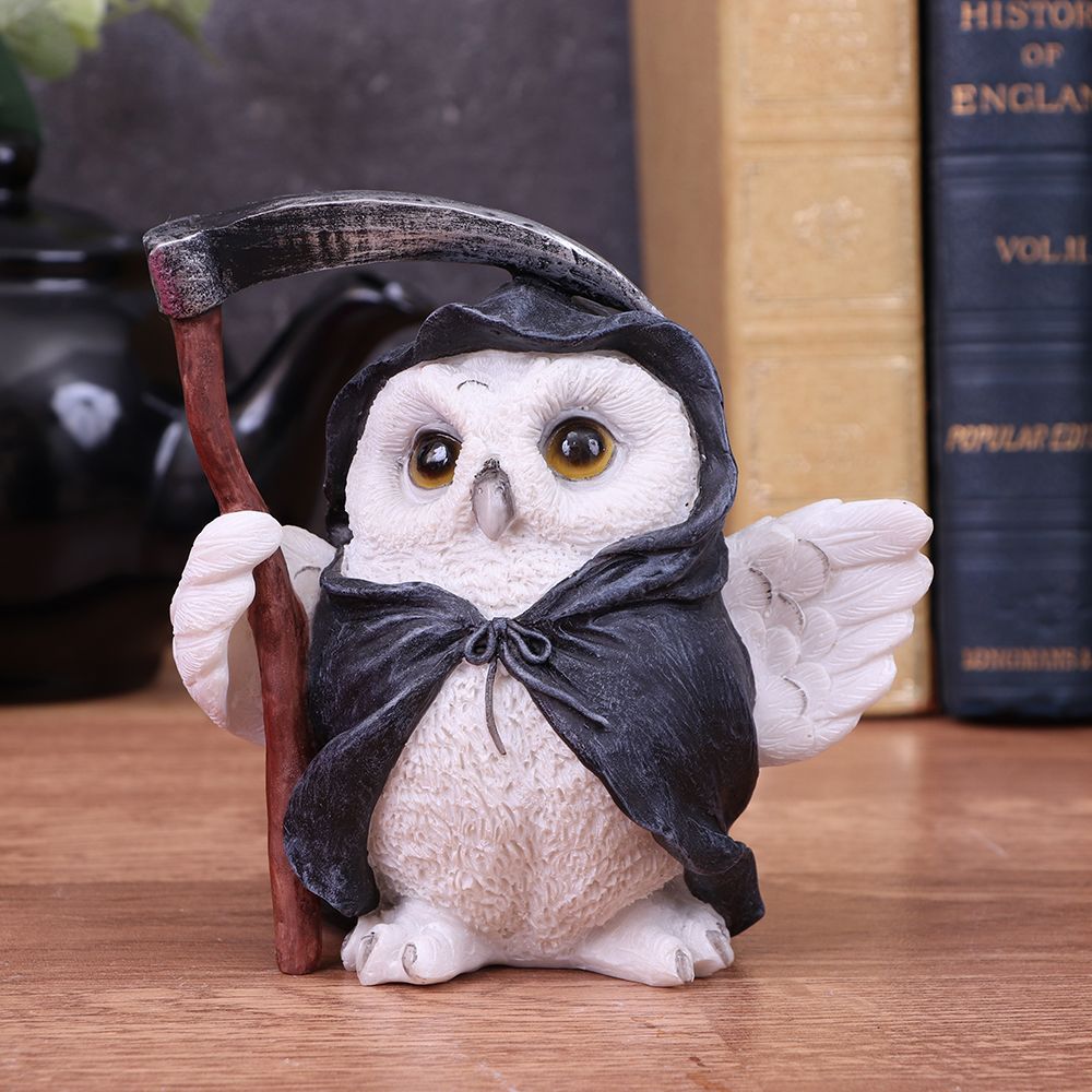 This quirky owl comes filled with character. A Snowy feathered friend stands proudly, a small scythe clasped in their small white wing. Surrounding their small body, a dark black cloak is draped, the most adorable epitome of death. Cast in the finest resin before being painstakingly hand-painted, this item will look great on any bookshelf or mantel. Also available on the website is Snowy Magic Witch Owl Familiar Figurine
