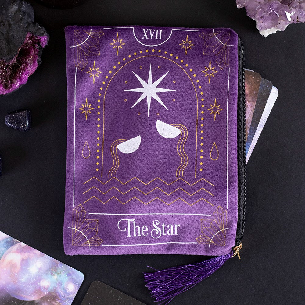 This velvet zipper pouch is the perfect place to keep tarot decks, crystals, beauty products and other treasures. Features a stunning white and gold star tarot card illustration on the front and a matching tassel and gold star charm on the zipper. Size: H: 15cm x W: 20cm x D: 0.75cm Material: Polyester