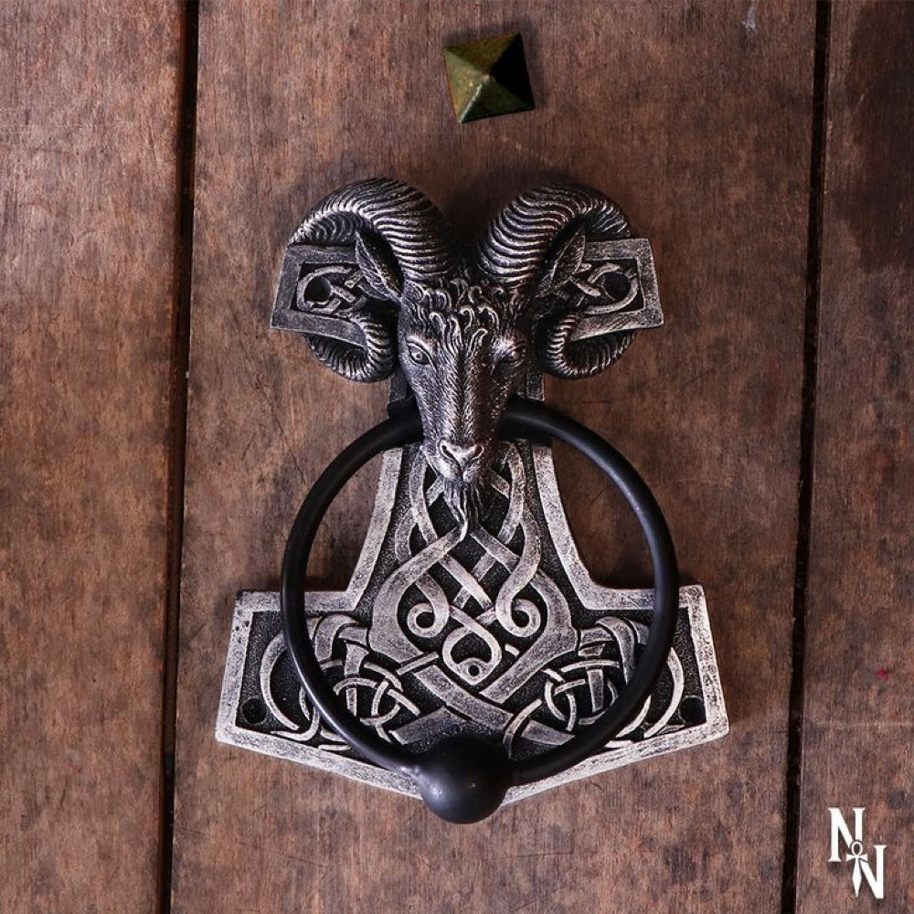 The head of a ram, horns curled around the top of the hammer holds the door knocker in its mouth. The knocker part is a solid metal ring, weighted to provide a loud knock. This Thor’s Hammer Door Knocker would make the perfect addition to any lover of the Viking Age.