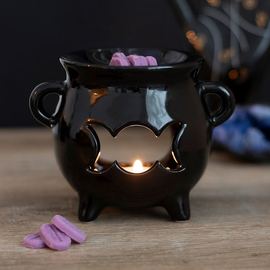 Adding to the range of the best selling Cauldron Oil Burner and the Black Cat Oil Burner, comes this sleek black glossy cauldron with a cut out triple moon design. Designed by Something Different and part of the Black Magic Collection of witchy gifts and homeware. These oil burners can also be used with wax and pair perfectly with our exclusive range (sold separately).