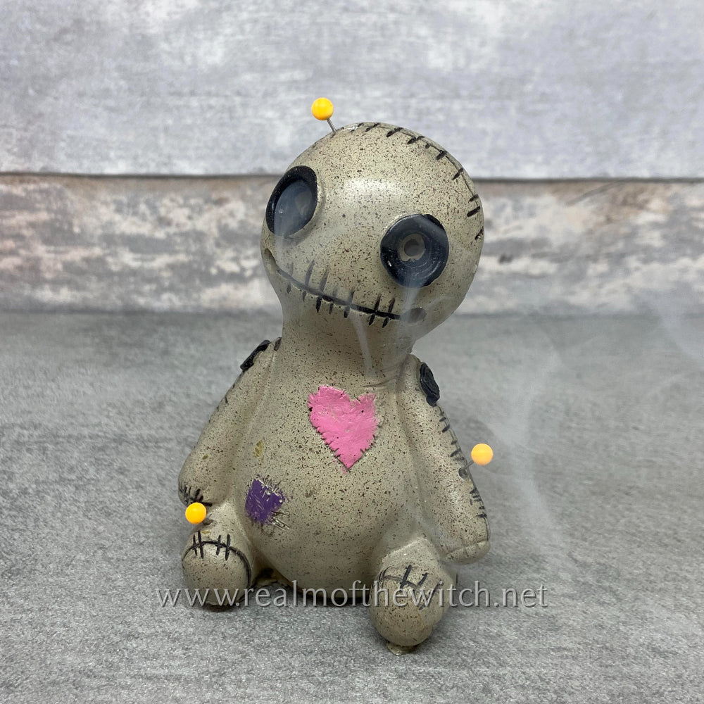 This adorable little doll is hand painted and looks just like the real thing! He sports a little pink heart that looks as though it's been stitched on, a stitched together mouth as well as button holes for eyes where the smoke from the incense cone escapes and a stitched mouth, where smoke can also be seen from tiny holes either side on the outer edges. The stitching around the rest of his body, along with other little patches completes his look with three sewing pins added for effect. 