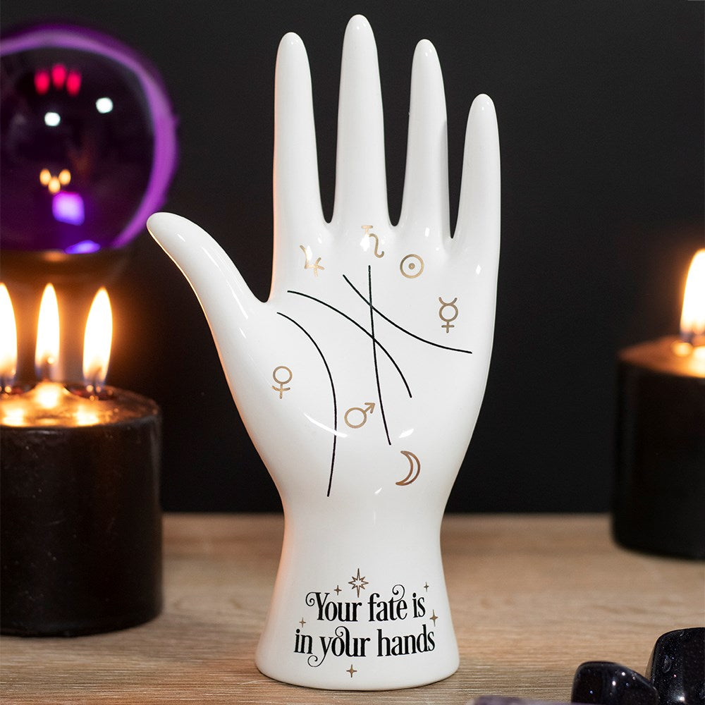 This cool take on a classic palmistry hand features metallic gold astrology symbols representing the Sun, Moon, Venus, Mars, Jupiter, Saturn and Mercury and mystical 'Your fate is in your hands' text. Can be used to hold rings and other accessories or on its own as a fun conversation piece.   Size: H: 20cm x W: 10cm x D: 5.5cm