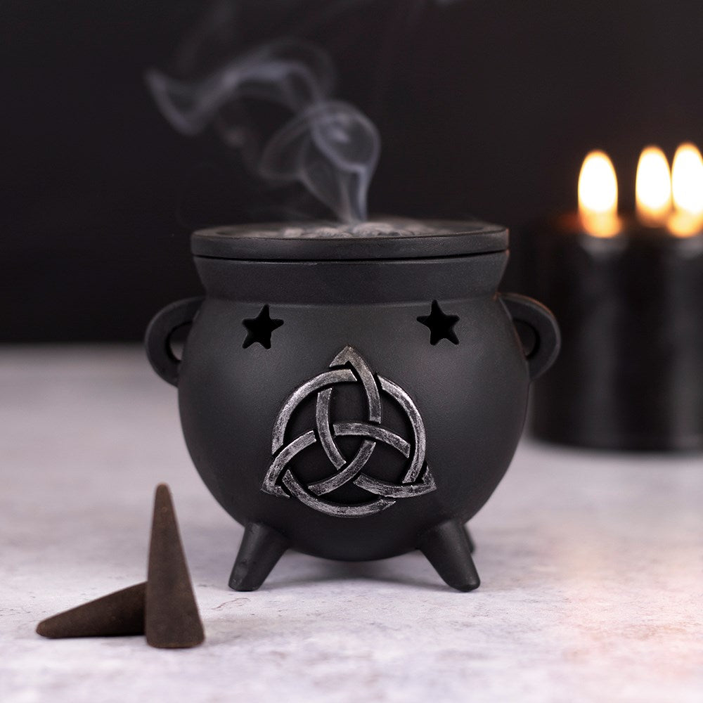 Place your favourite scented incense cones in this magical cauldron, pop the lid on and watch the smoke rise up like a steaming hot brew! Accented by cut out stars and a distressed silver-effect triquetra design, with a removable 'bubbling' brew top. Size: H: 8cm x W: 10cm x D: 9cm