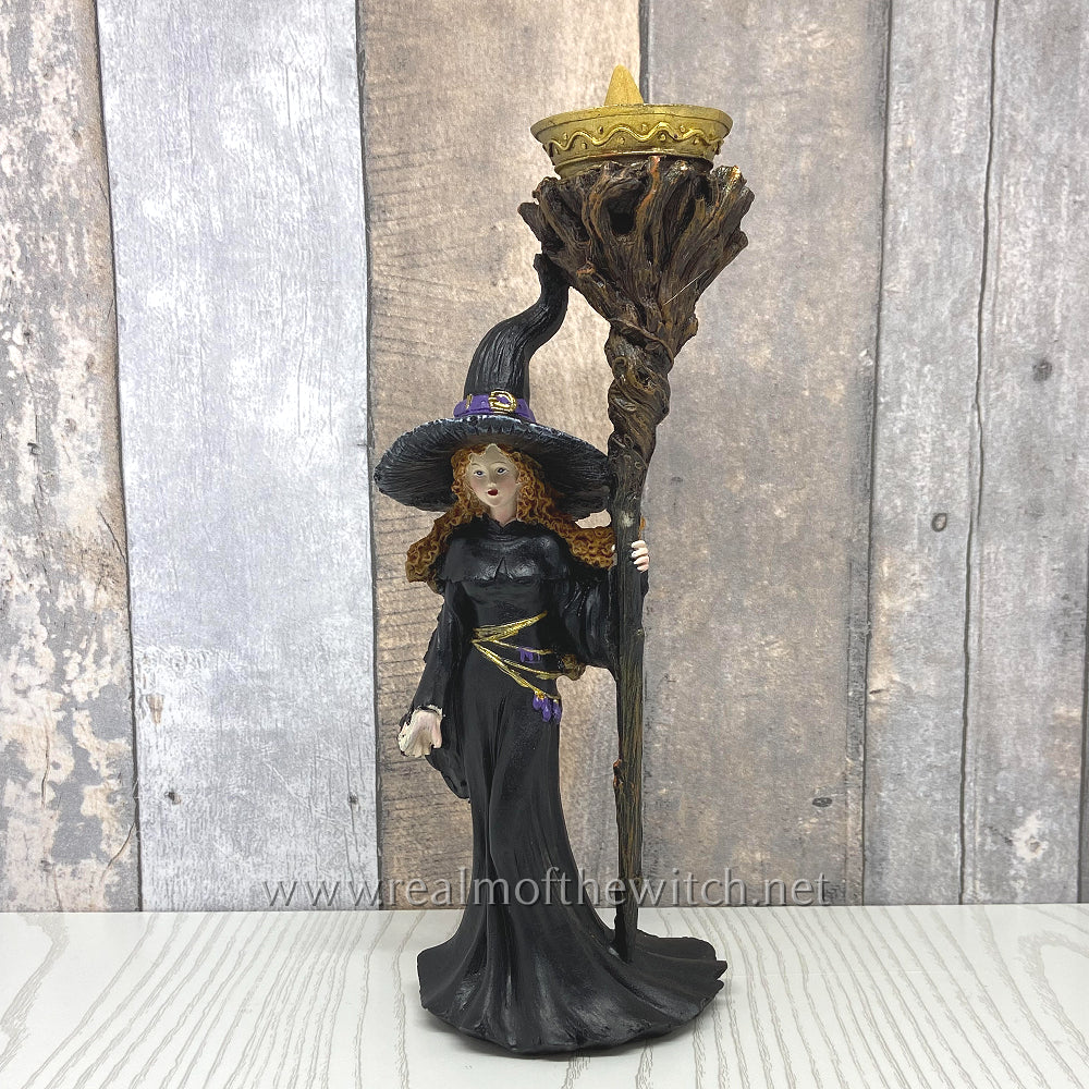 A detailed witch holds a twisted, wooden staff on this amazing backflow incense cone burner. To use, simply place an incense cone into the golden dish and watch as smoke swirls from the staff's branches.