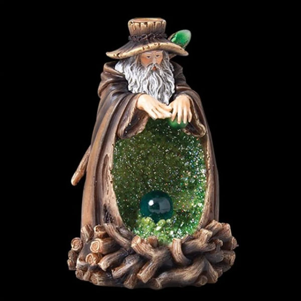 This unique backflow burner features a wise, old wizard standing over a sparkling crystal cave and lighted crystal ball. Place a backflow incense cone atop his hat and watch as the smoke gently flows through the glittering crystals. Perfect for the wise sage in your life!  Powered by an on/off switch and 2 AA batteries (not supplied).