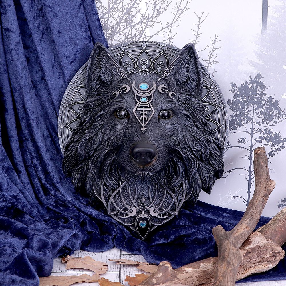 Modelled on the face of the dark Wolf, this beautiful creature stares straight ahead, piercing the souls of all who catch its gaze. Channelling the spirit of the wolf moon, this beast has the lunar phases emblazoned across its head to the bridge of its nose. Aquamarine jewels give a soft glow to an otherwise dark sculpture. Cast in the finest resin before being hand-painted, this large piece would make a bold display piece for any home.