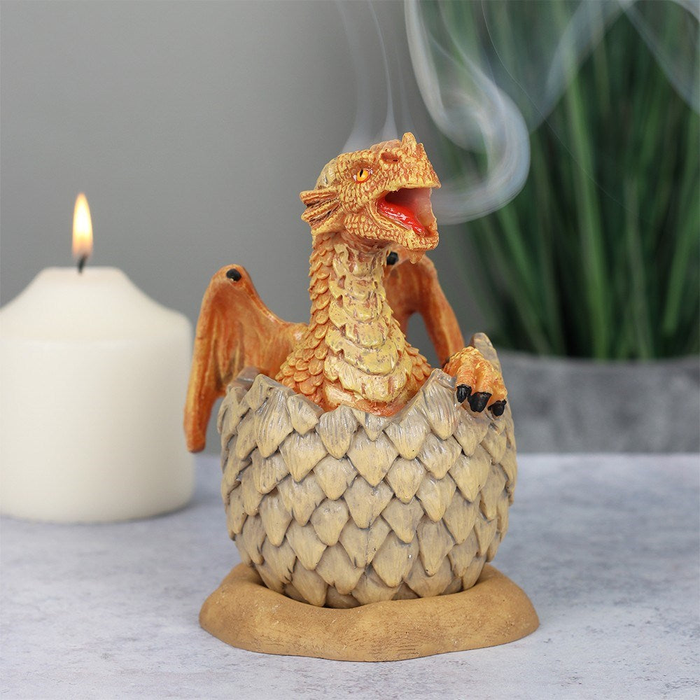 Designed by Anne Stokes, this eye-catching incense cone burner features a yellow and orange dragon hatching from an egg. When an incense cone is lit and placed inside the smoke from the cone will flow through the mouth of the dragon for an impressive feature piece. 