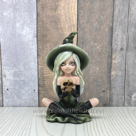 Wearing a matching green dress and pointed hat, Zelda sits cross-legged on the floor holding a human skull. Her face is made up and is beautifully framed by her light platinum hair, detailed with lime highlights. The perfect gift for you or your witchy friends and family! 